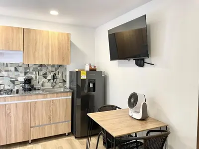 a kitchen with a refrigerator and a table with chairs at Casa palmera cozy loft 301 near everything in Envigado