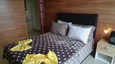 a bedroom with a bed with a yellow blanket on it at Stone's chalets Guatapé in Guatapé