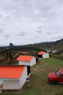 a red car parked in front of white buildings at Stone's chalets Guatapé in Guatapé