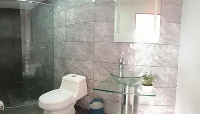 a bathroom with a toilet and a glass sink at Stone's chalets Guatapé in Guatapé
