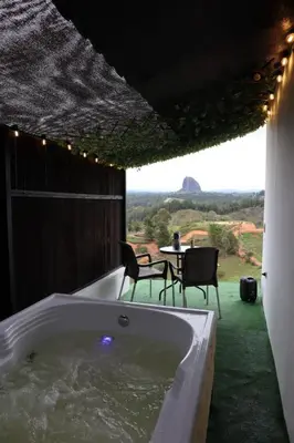 a bath tub in a room with a table and chairs at Stone's chalets Guatapé in Guatapé