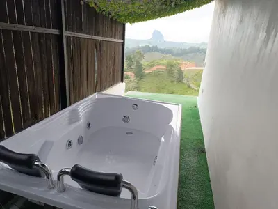 a white bath tub in a room with a window at Stone's chalets Guatapé in Guatapé
