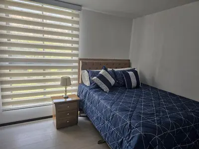 a bedroom with a blue bed and a window at departamento amoblado in Sabaneta