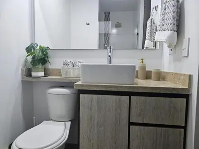 a bathroom with a white toilet and a sink at departamento amoblado in Sabaneta