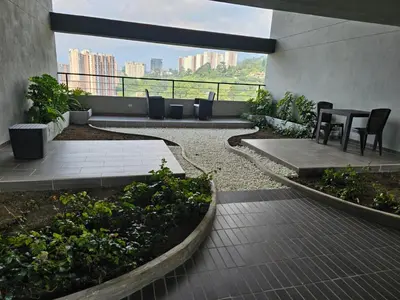 a patio with a table and chairs on a building at departamento amoblado in Sabaneta