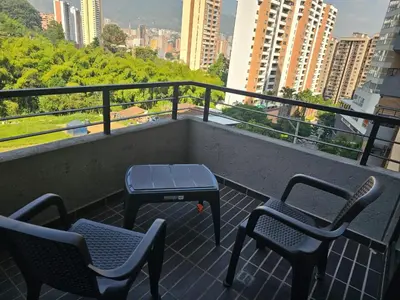 a balcony with two chairs and a grill on it at departamento amoblado in Sabaneta