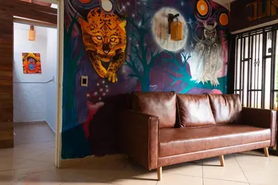 a couch in a room with a painted wall at Jungle House Medellin in Medellín
