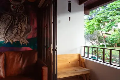a room with a bench and a window with an owl on the wall at Jungle House Medellin in Medellín