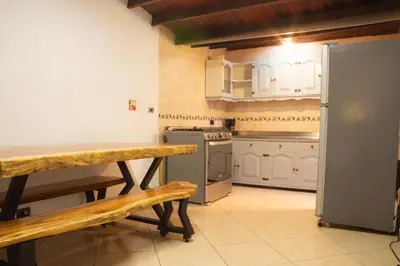 a kitchen with white cabinets and a bench in it at Jungle House Medellin in Medellín