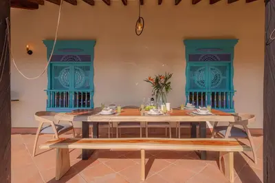 a dining room with a table and blue windows at Vista Bonita - Hacienda Guatape in Guatapé