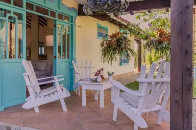 a patio with white chairs and a table at Vista Bonita - Hacienda Guatape in Guatapé