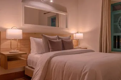 a bedroom with a large bed with two lamps at Vista Bonita - Hacienda Guatape in Guatapé
