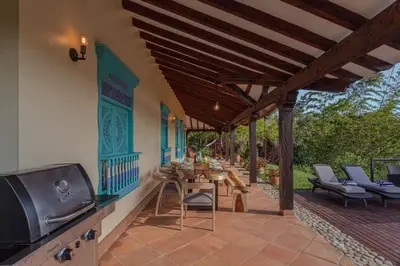 a patio with a table and chairs and a tv at Vista Bonita - Hacienda Guatape in Guatapé