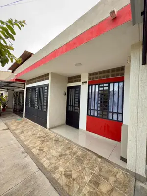 a building with red doors and a sidewalk at Estrena confortable casa in Mariquita