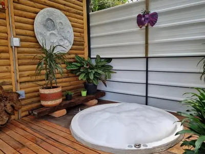 a large white bath tub sitting on a wooden deck at Mágica Cabaña con jacuzzi en Santa Elena in Santa Elena