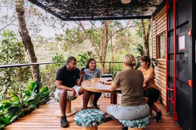 a group of people sitting around a table on a deck at Mágica Cabaña con jacuzzi en Santa Elena in Santa Elena