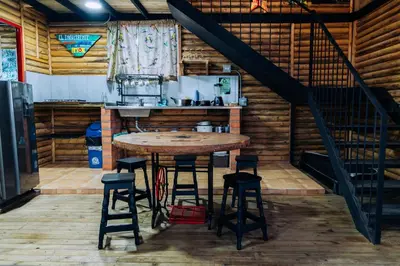 a kitchen with a table and stools in a room at Mágica Cabaña con jacuzzi en Santa Elena in Santa Elena