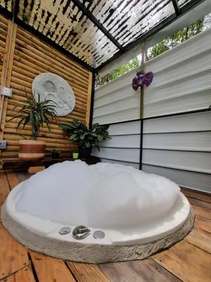 a large white bath tub sitting on top of a wooden floor at Mágica Cabaña con jacuzzi en Santa Elena in Santa Elena
