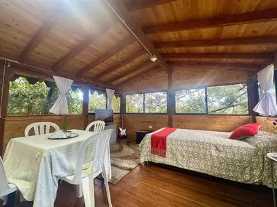 a bedroom with a bed and a table in a room at Refugio del Pino santa elena in Santa Elena