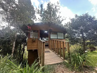 a cabin in the woods with a wooden deck at Refugio del Pino santa elena in Santa Elena