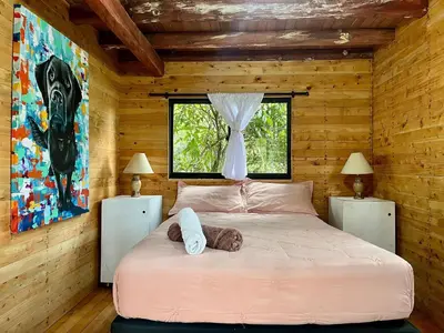 a bedroom with a large bed in a wooden room at Refugio del Pino santa elena in Santa Elena