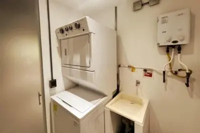 a small kitchen with a white refrigerator with a stove at Astorga loft by Host Medellin in Medellín