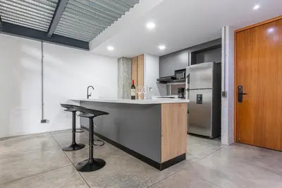 a kitchen with a counter and a refrigerator at Astorga loft by Host Medellin in Medellín