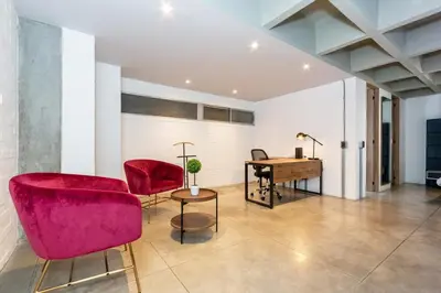 a living room with red chairs and a desk at Astorga loft by Host Medellin in Medellín