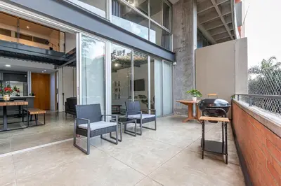 a patio with chairs and a grill in a building at Astorga loft by Host Medellin in Medellín