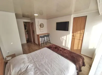 a bedroom with a bed and a table and a television at Apartaestudio S201 a 2 calles Milán Urbanevo in Manizales