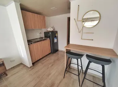 a small kitchen with a table and two stools at Apartaestudio S201 a 2 calles Milán Urbanevo in Manizales