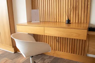 a desk with a chair and a speaker on a wooden wall at Luxury Guatapé Loft with Starlink WiFi & Jacuzzi in Chiquinquirá