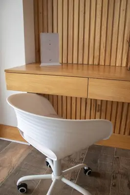 a white chair sitting in front of a wooden desk at Luxury Guatapé Loft with Starlink WiFi & Jacuzzi in Chiquinquirá