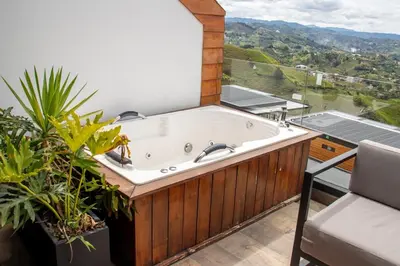 a jacuzzi tub on the balcony of a house at Luxury Guatapé Loft with Starlink WiFi & Jacuzzi in Chiquinquirá