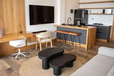 a living room with a kitchen with a table and chairs at Luxury Guatapé Loft with Starlink WiFi & Jacuzzi in Chiquinquirá