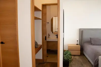 a bedroom with a bed and a sink and a mirror at Luxury Guatapé Loft with Starlink WiFi & Jacuzzi in Chiquinquirá