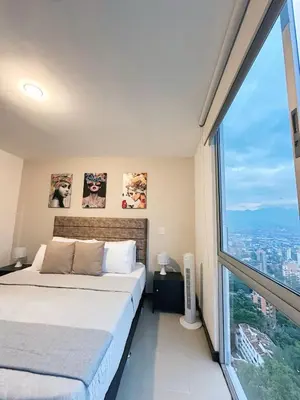 a bedroom with a bed and a large window at 23rd Floor Luxury Apartment 5 Min from Provenza in Medellín
