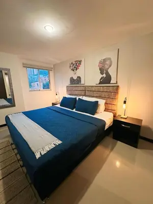 a bedroom with a large bed with a blue blanket at 23rd Floor Luxury Apartment 5 Min from Provenza in Medellín