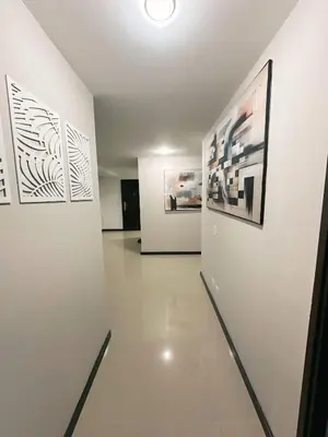 a hallway with white walls and pictures on the wall at 23rd Floor Luxury Apartment 5 Min from Provenza in Medellín