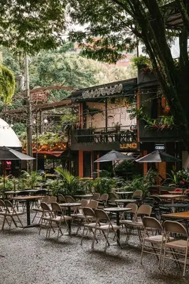 a group of tables and chairs in front of a building at 23rd Floor Luxury Apartment 5 Min from Provenza in Medellín