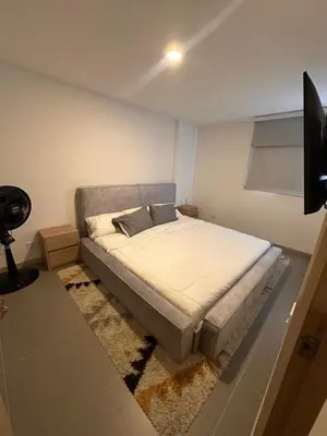a bedroom with a bed and a flat screen tv at Luxurious and Modern Apartment in Medellín