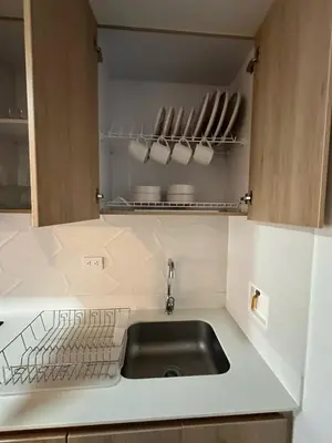 a kitchen with a sink and a shelf with utensils at Luxurious and Modern Apartment in Medellín