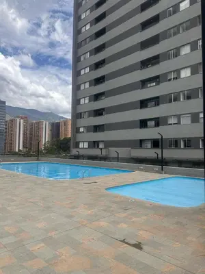 a swimming pool in front of a tall building at Luxurious and Modern Apartment in Medellín