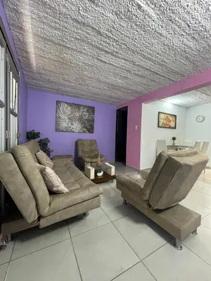 a living room with a couch and purple walls at Apartamento cerca al aeropuerto Olaya herrera in Medellín
