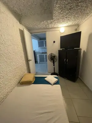 a small room with a bed and a flat screen tv at Apartamento cerca al aeropuerto Olaya herrera in Medellín