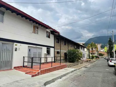 a group of houses on a street with mountains in the background at Apartamento cerca al aeropuerto Olaya herrera in Medellín