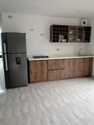 a kitchen with a black refrigerator and wooden cabinets at Villa Maru in El Peñol