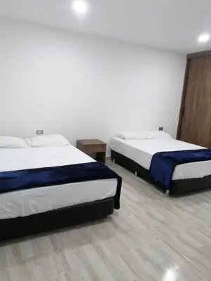 two beds are in a room with at Villa Maru in El Peñol