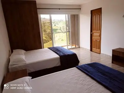 two beds in a room with a window at Villa Maru in El Peñol