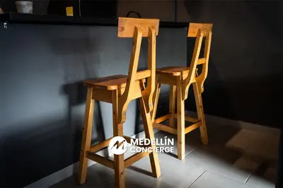 a pair of wooden chairs sitting next to a counter at 2BR House Jacuzzi & AC in Poblado Manila in Medellín